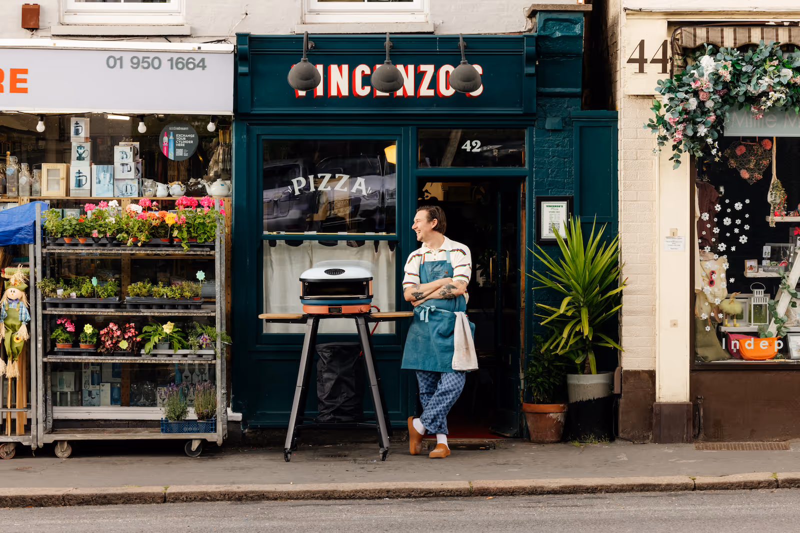 Tom standing outside of Vincenzo's Bushey next to a pizza oven