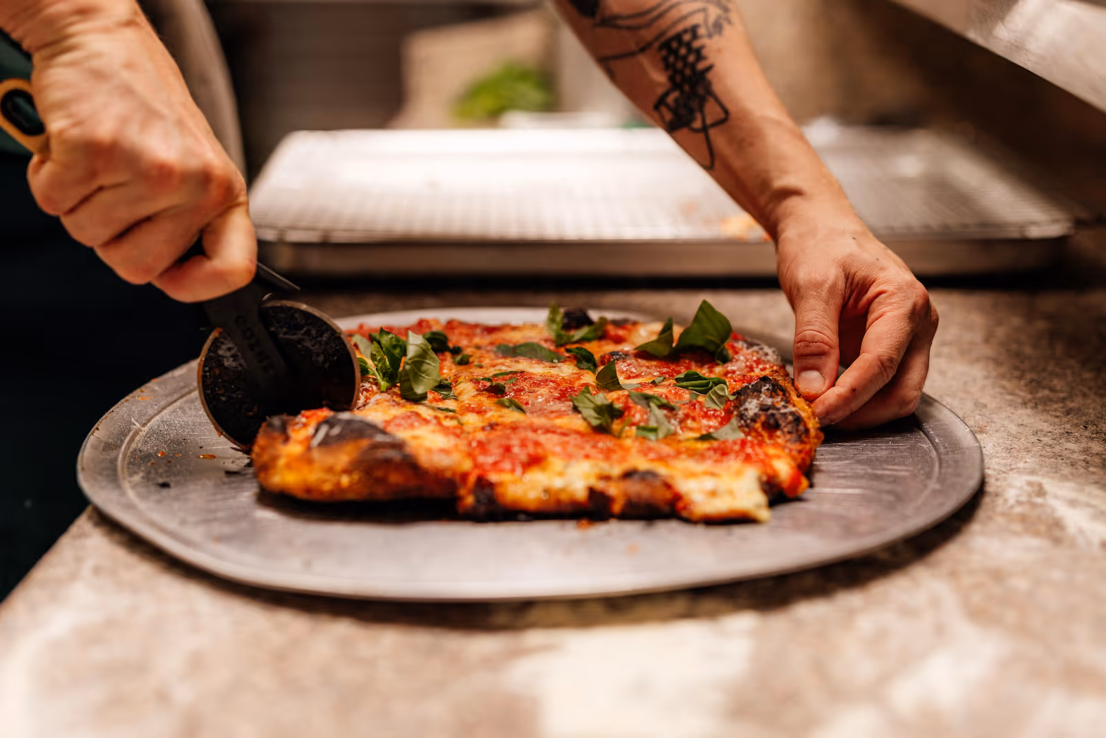 A large slice of pizza being cut by hand