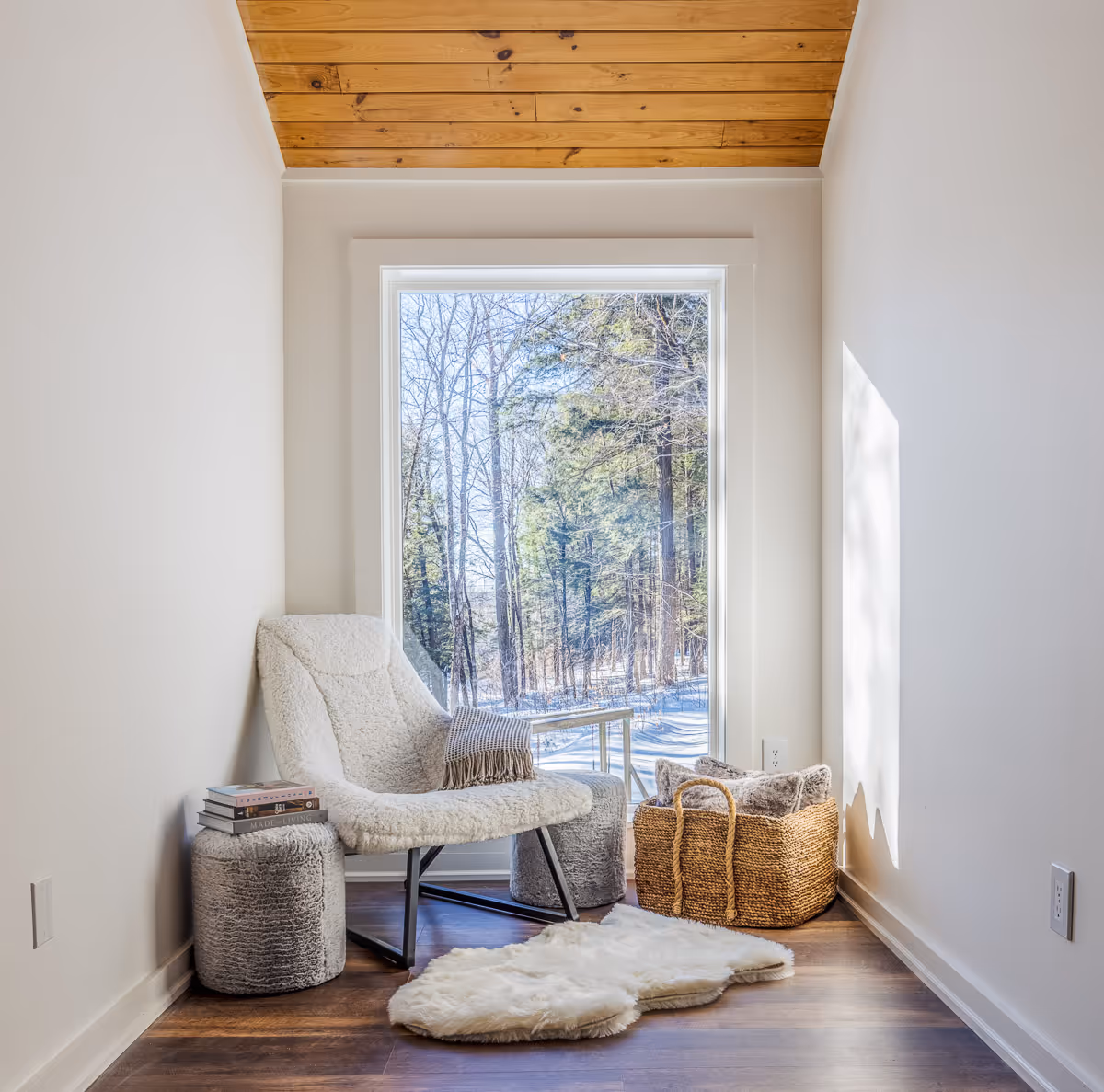 Cozy reading nook with armchair and window view of winter forest – interior photography