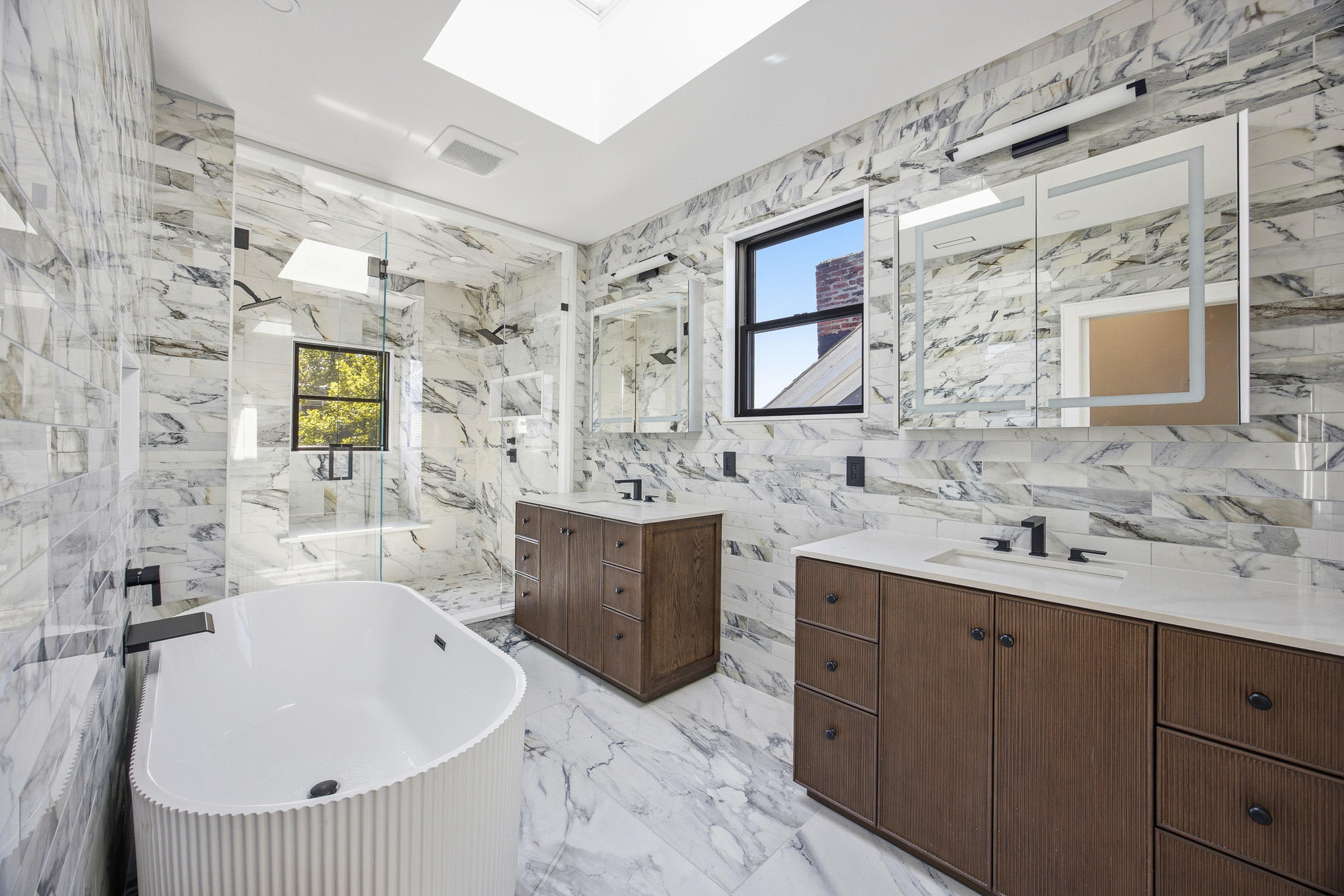 Marble bathroom with modern vanity and freestanding tub – real estate interiors