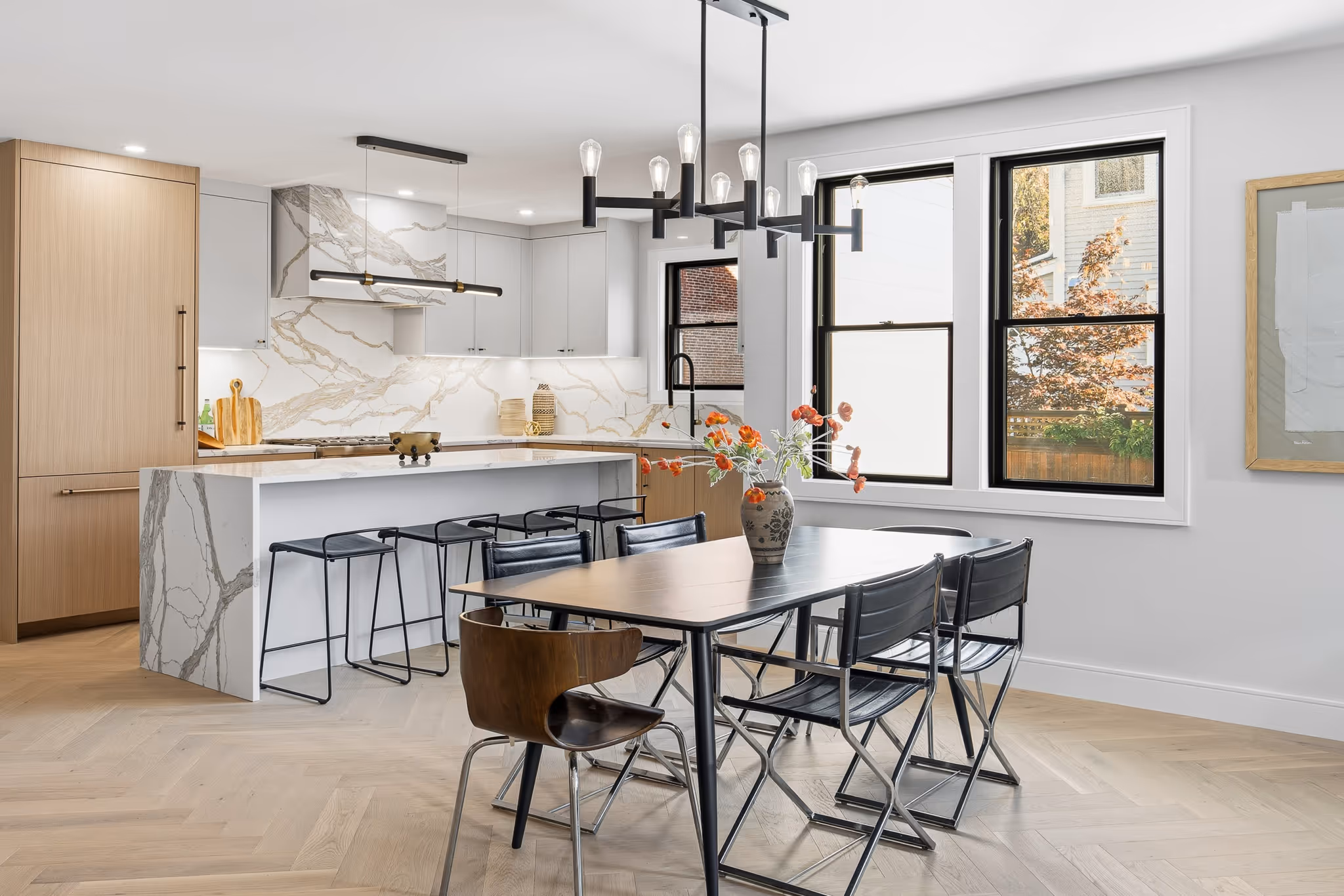 Bright open kitchen with large windows and dining table – real estate photography