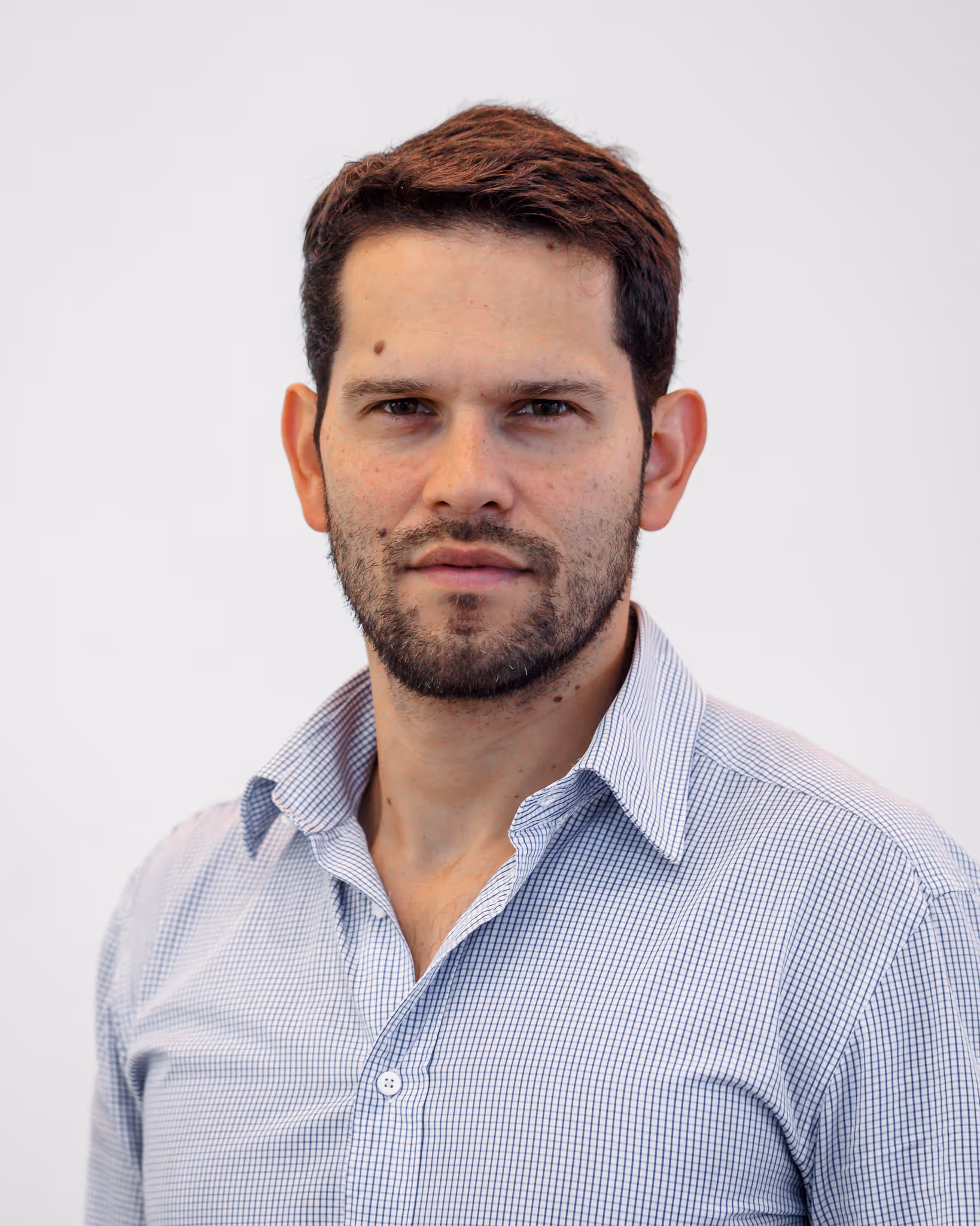 Professional headshot of man with beard on white background