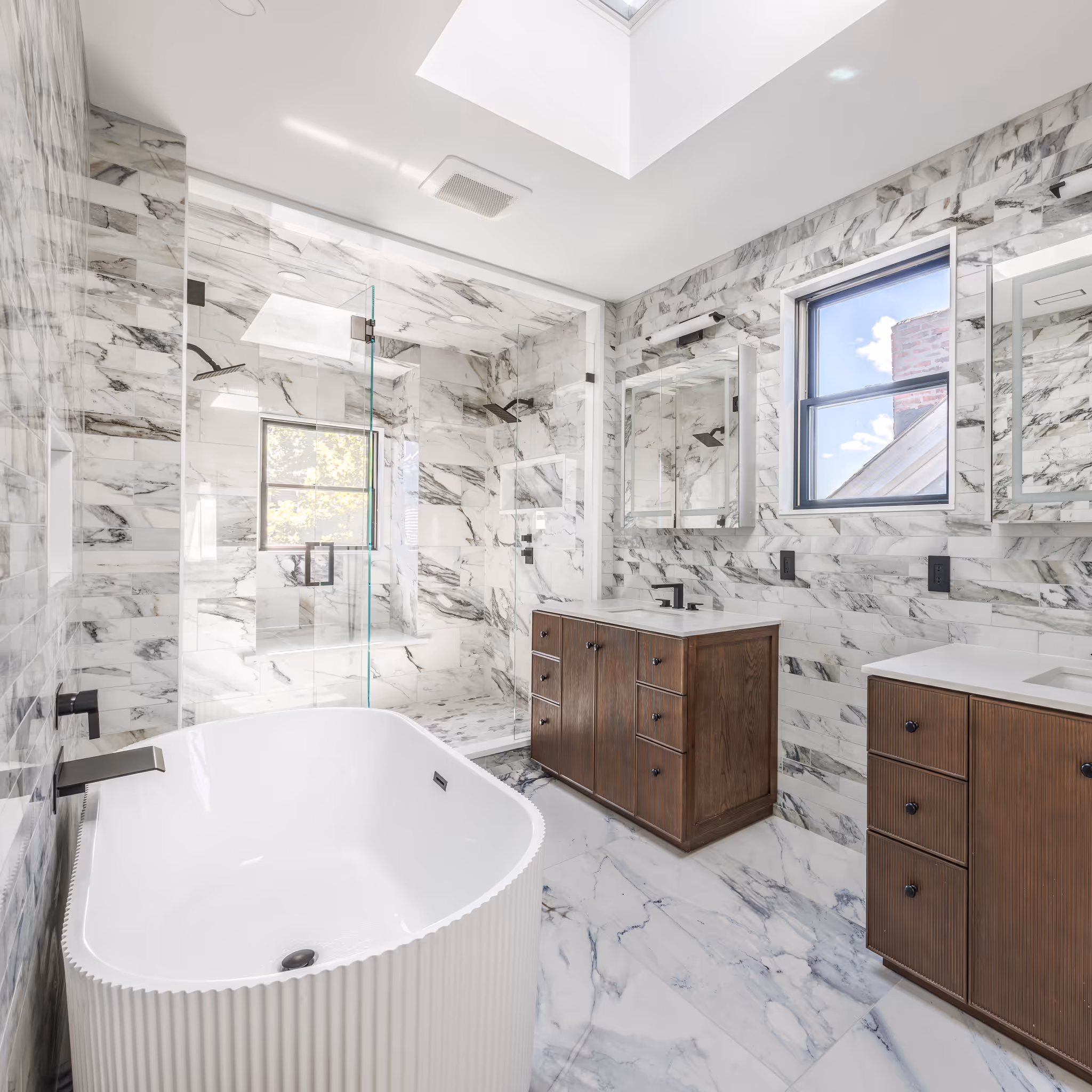 Luxury bathroom with marble walls, soaking tub, and double vanity – architecture photography