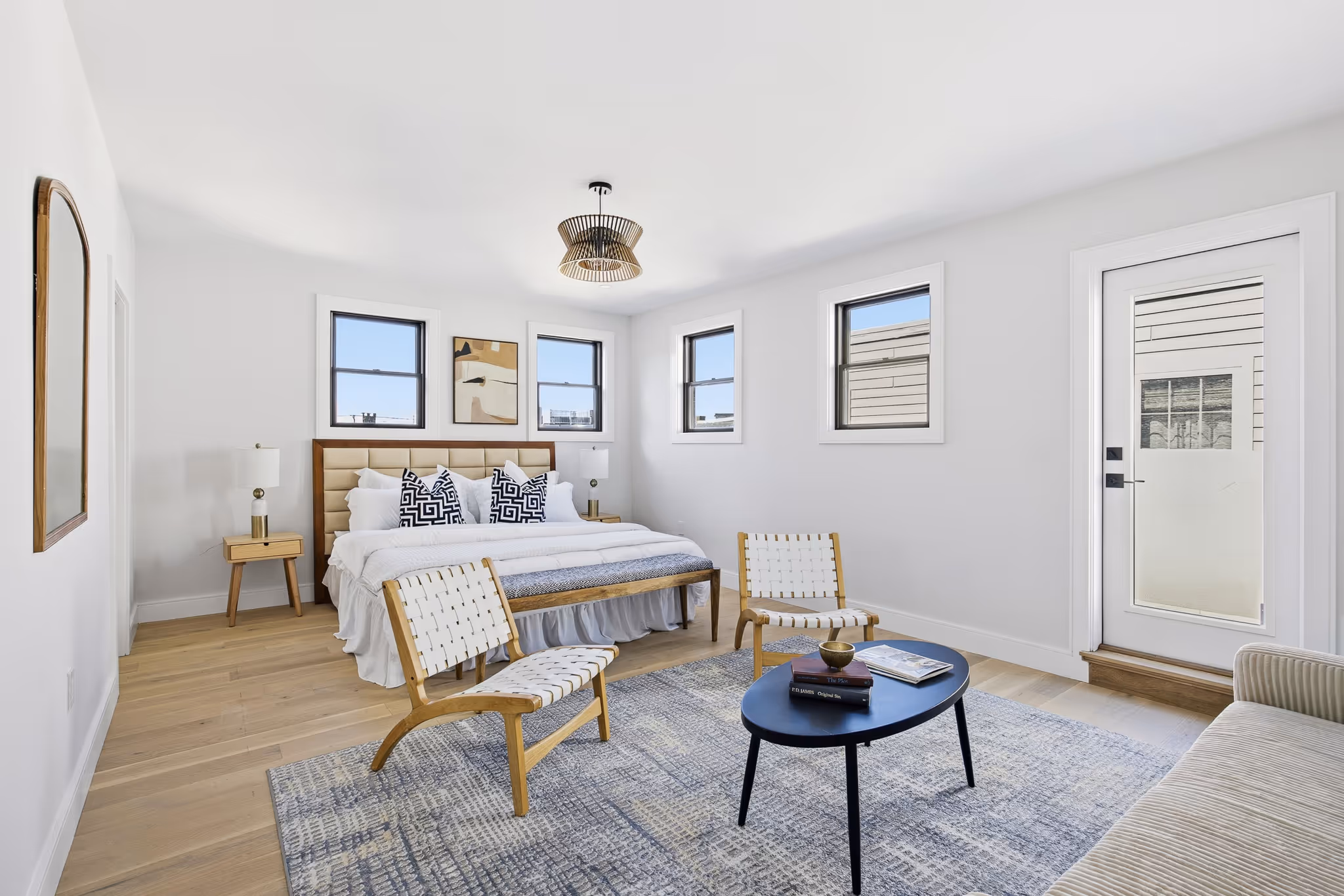Bedroom with wood floors, sectional sofa, and neutral decor.