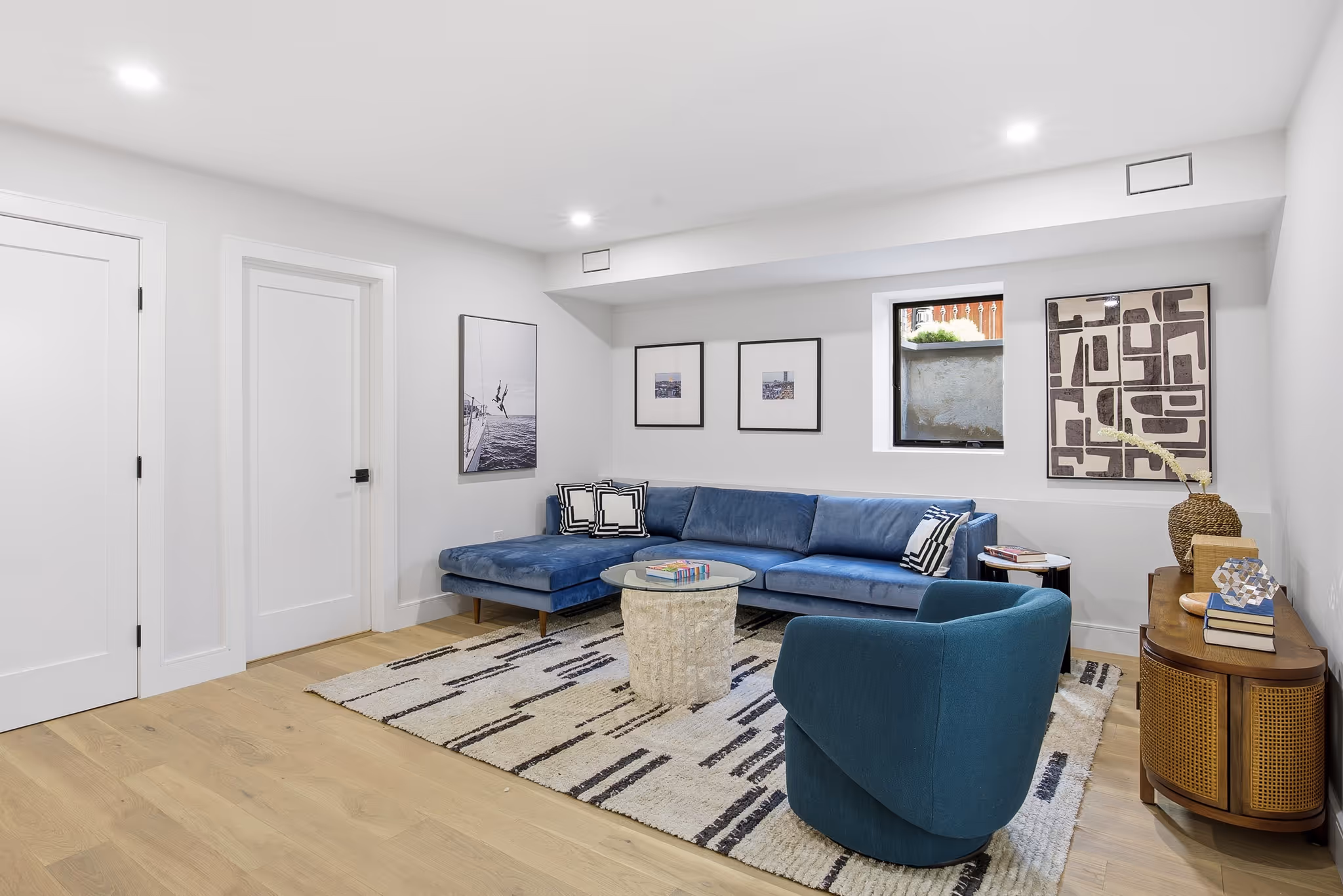 Spacious living room with beige sofa, rug, and framed artwork.