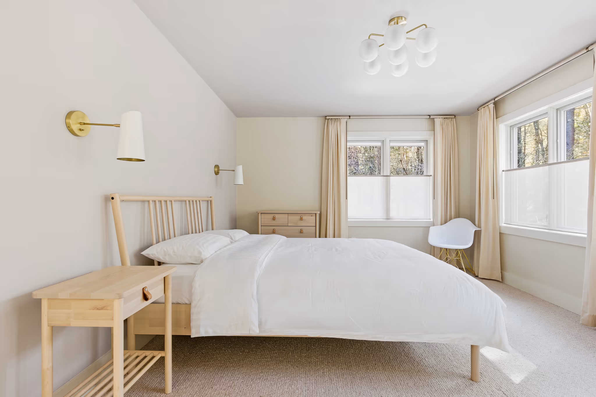 Bright primary bedroom with large windows and neutral decor.