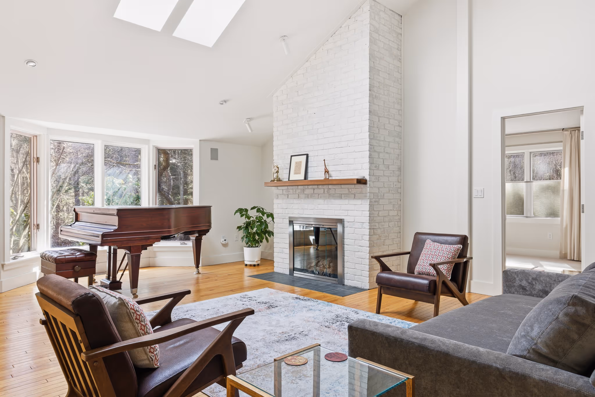 Cozy living room with fireplace, high ceilings, and seating area.