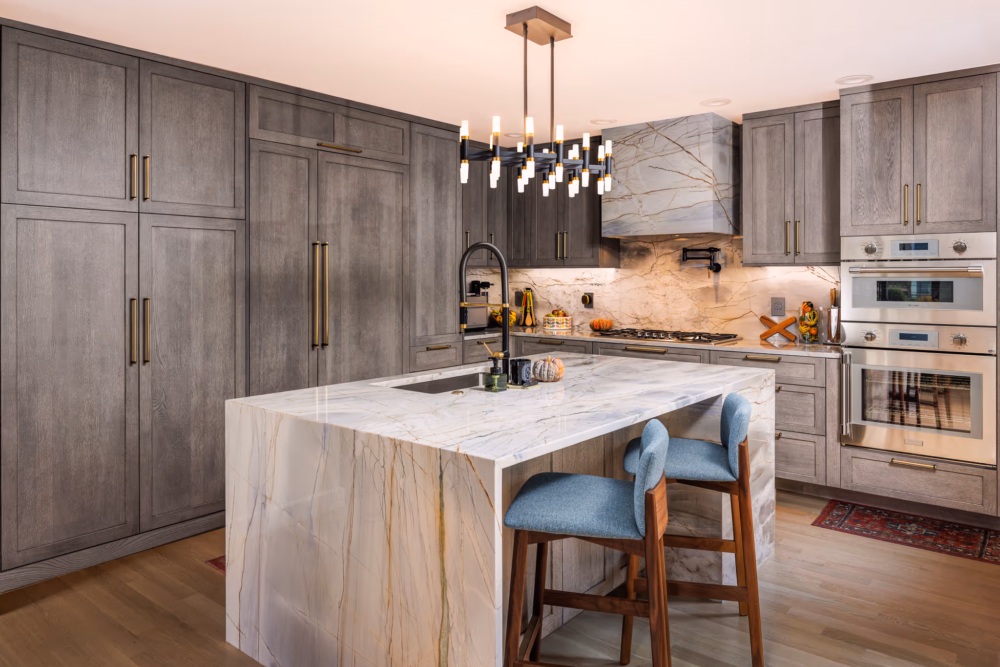 Luxury kitchen with marble island and pendant lighting.