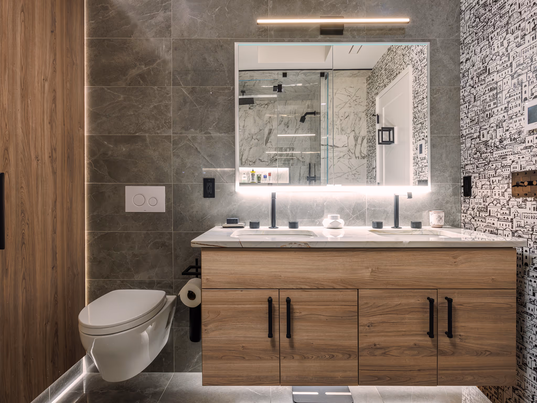 Modern bathroom with double vanity, wood cabinets, and tiled walls.
