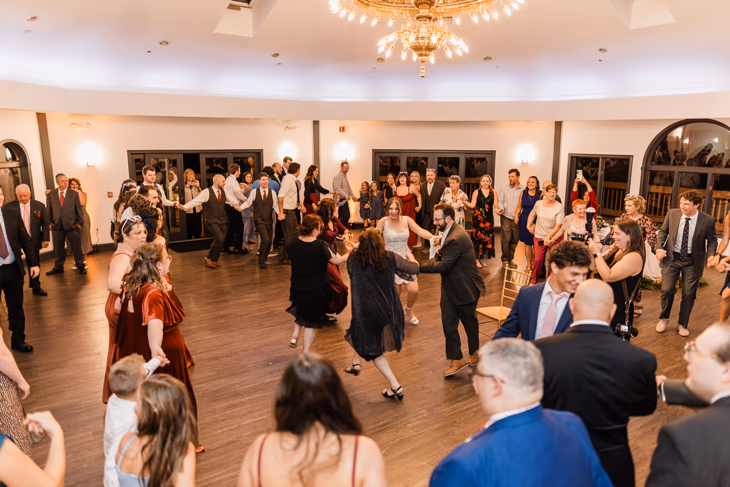Guests enjoying a dance at a Boston event photographed in a bright reception space.
