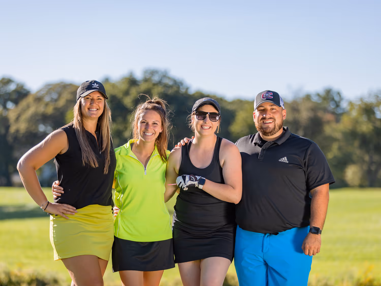 Group smiling outdoors at a Boston golf event photographed by Boston event photographer.