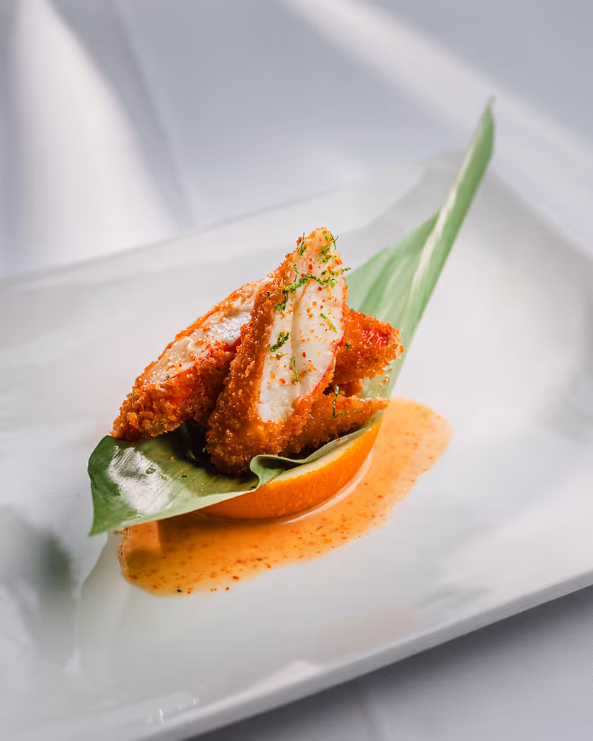 Minimalist fine dining presentation of crab cakes with sauce, photographed by a Boston restaurant photographer.