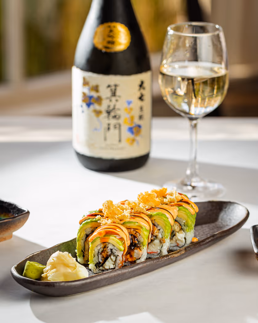Food photographer in Boston capturing sushi rolls with sake and wine on a restaurant table, professional restaurant photography.