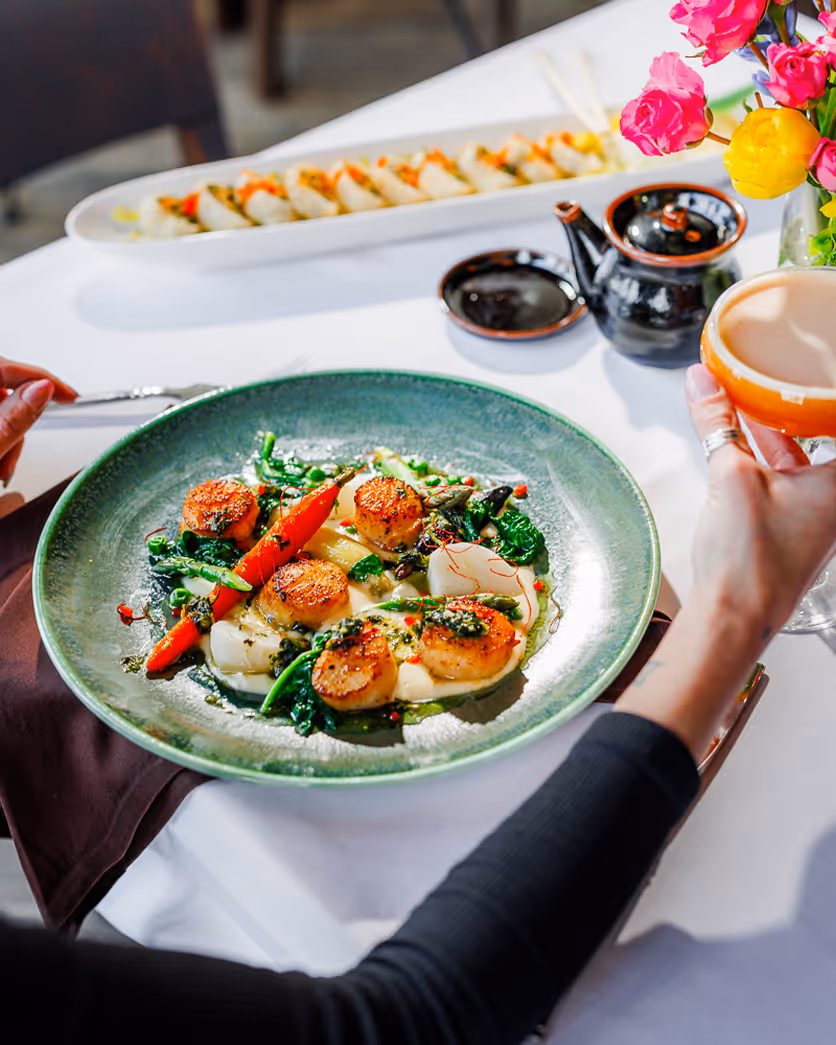 oston restaurant photographer capturing guests enjoying a colorful salad and cocktail at a fine dining table, professional food photography.
