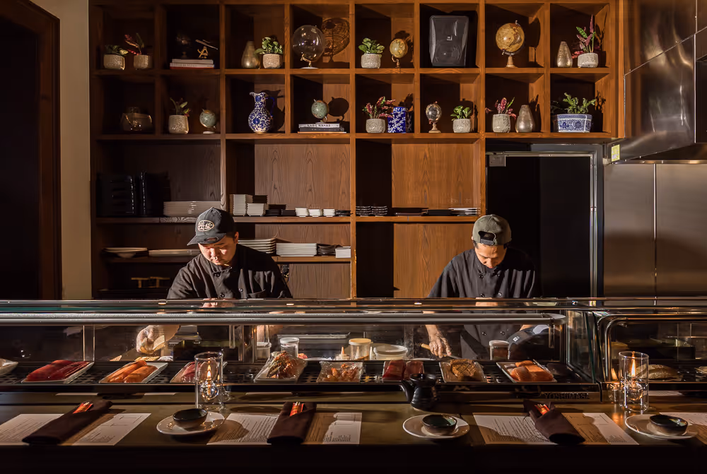 sushi chef behind sushi bar