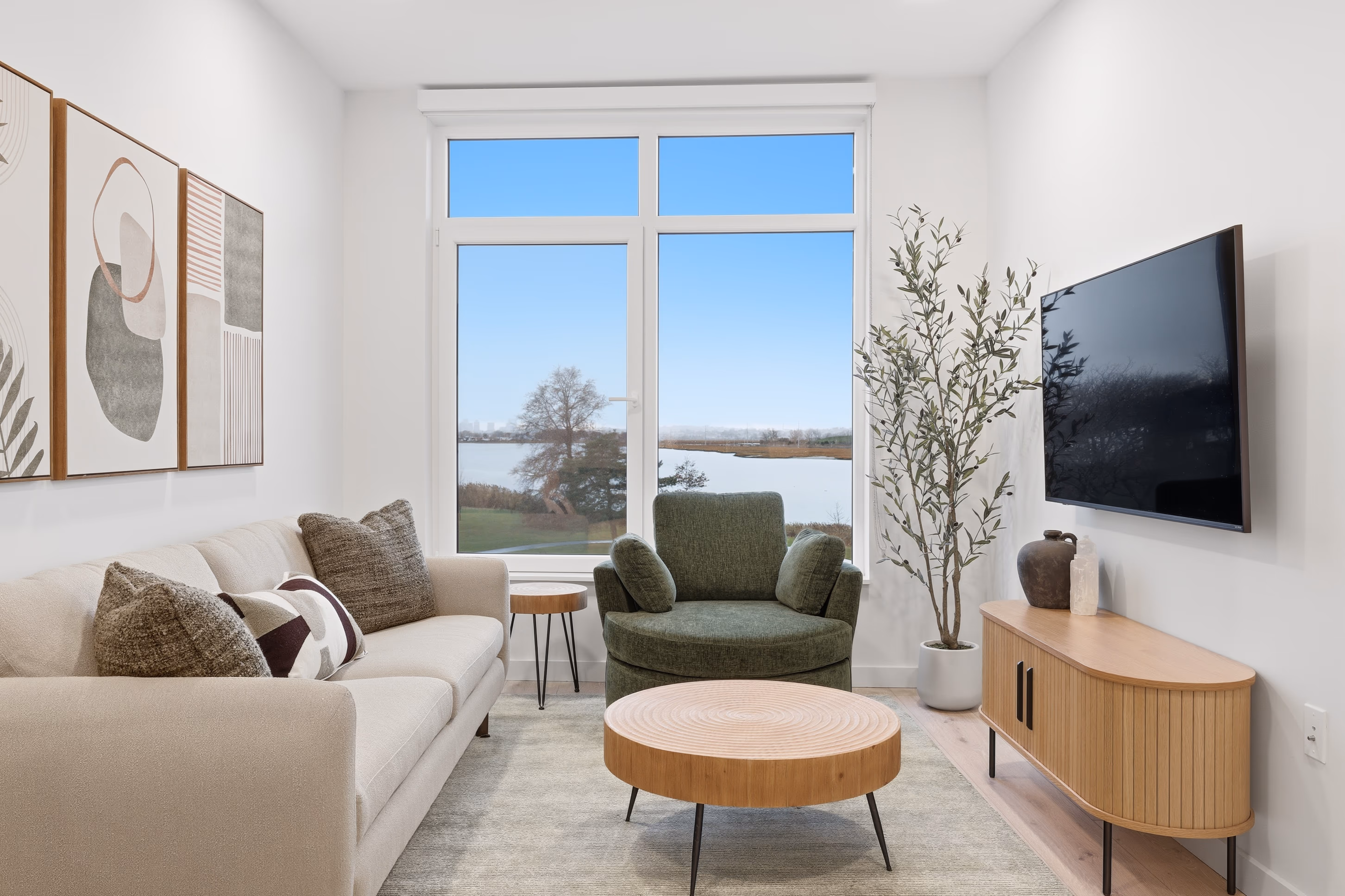 Living room with large windows, modern decor and bright natural light.