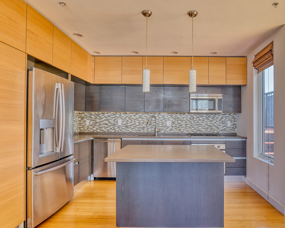 Kitchen before renovation with original cabinets, island and stainless steel appliances in South Boston condo
