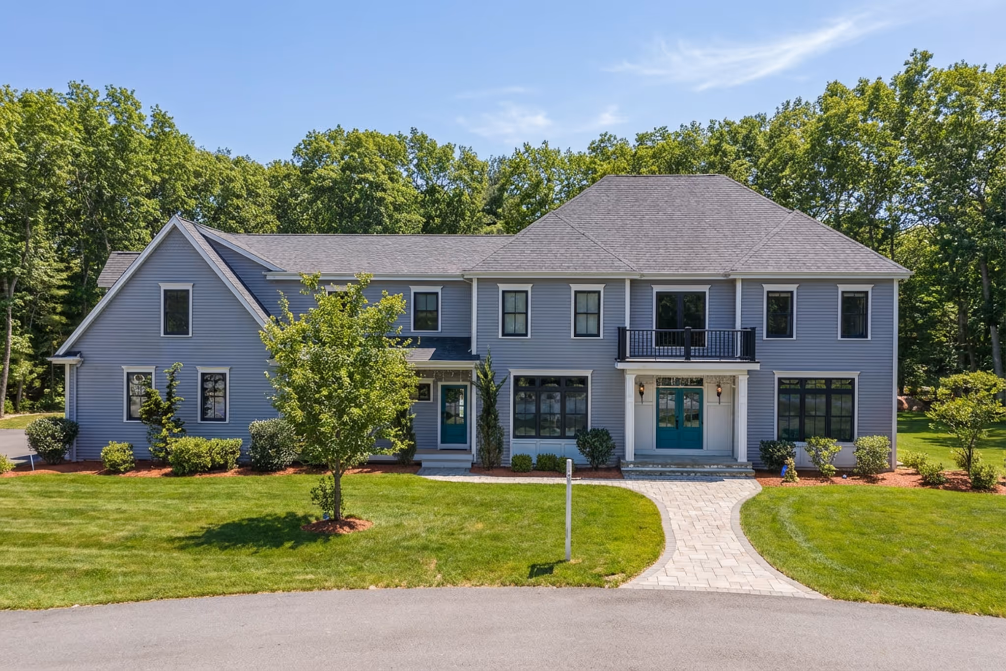 Daytime exterior of custom built colonial home in Plainville MA with landscaped front yard.