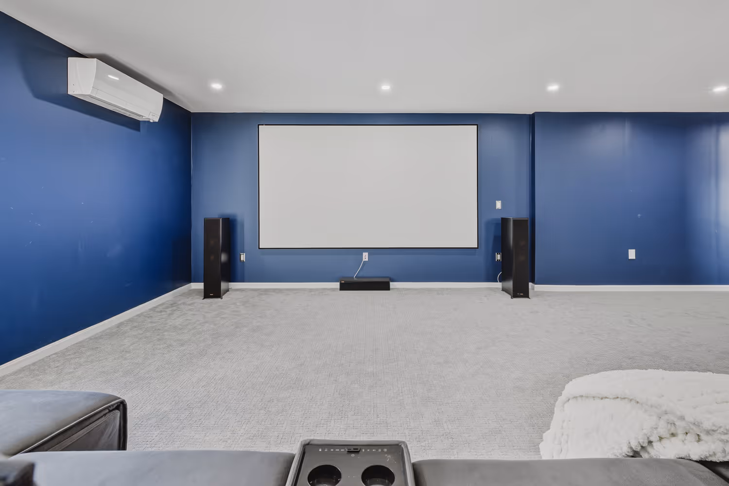 Home theater room with projector screen and built in speakers in Plainville MA.