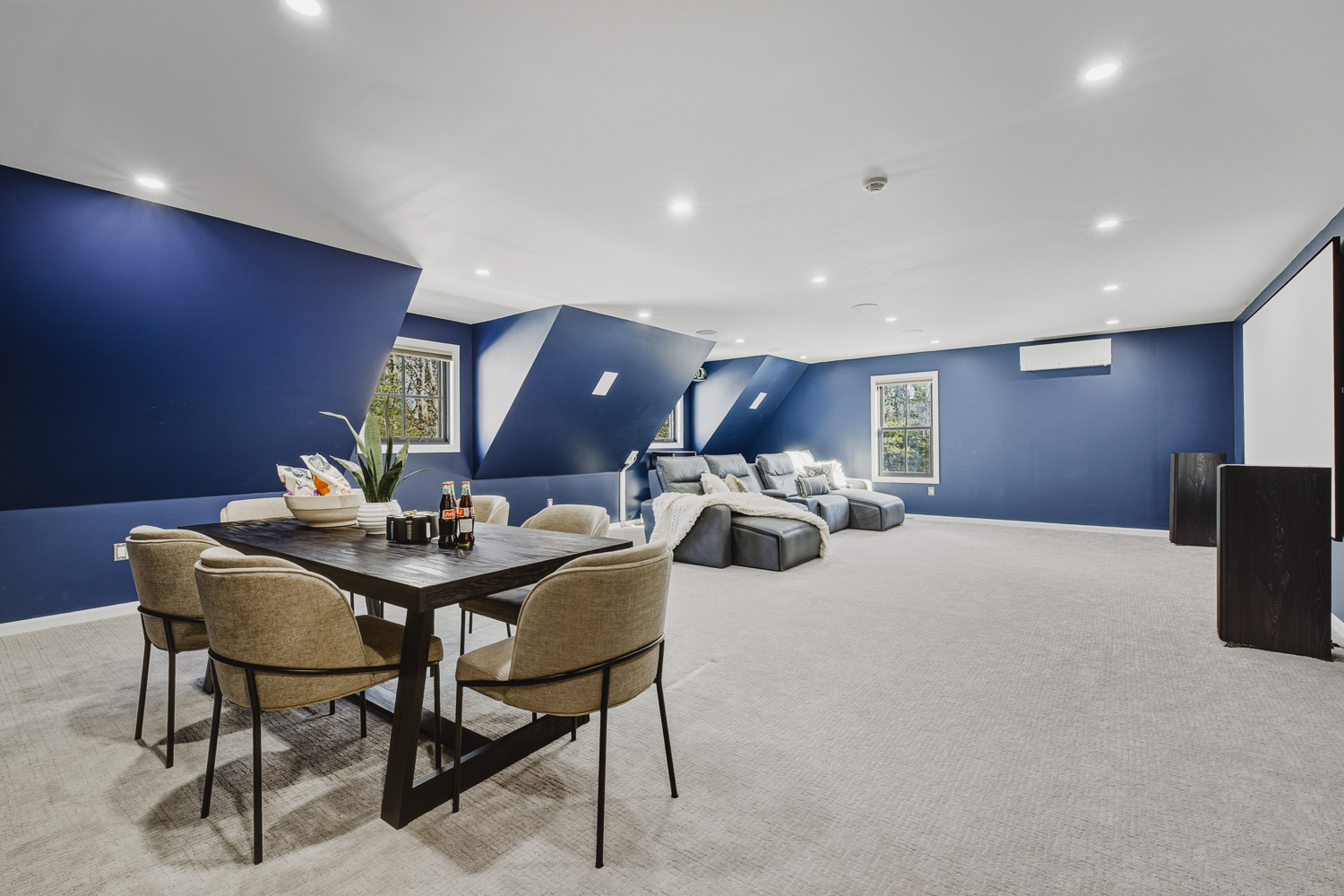 Finished basement lounge with blue accent wall and seating area in Plainville MA.