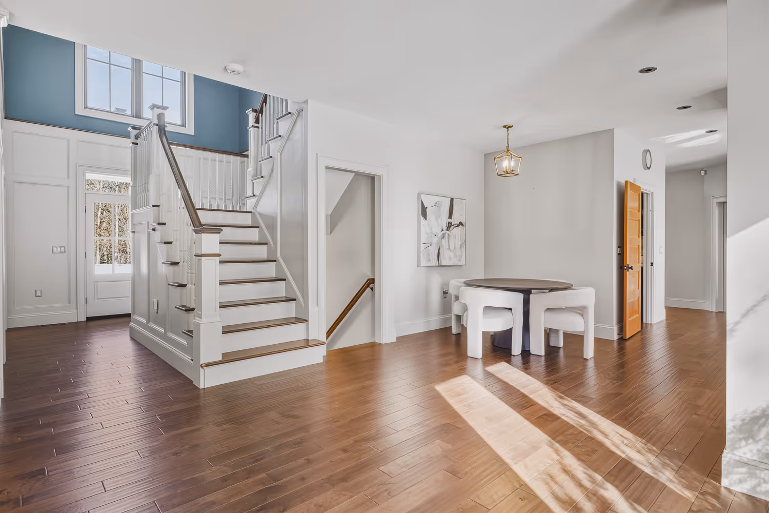 Interior staircase and open entryway with hardwood floors in Plainville MA home.