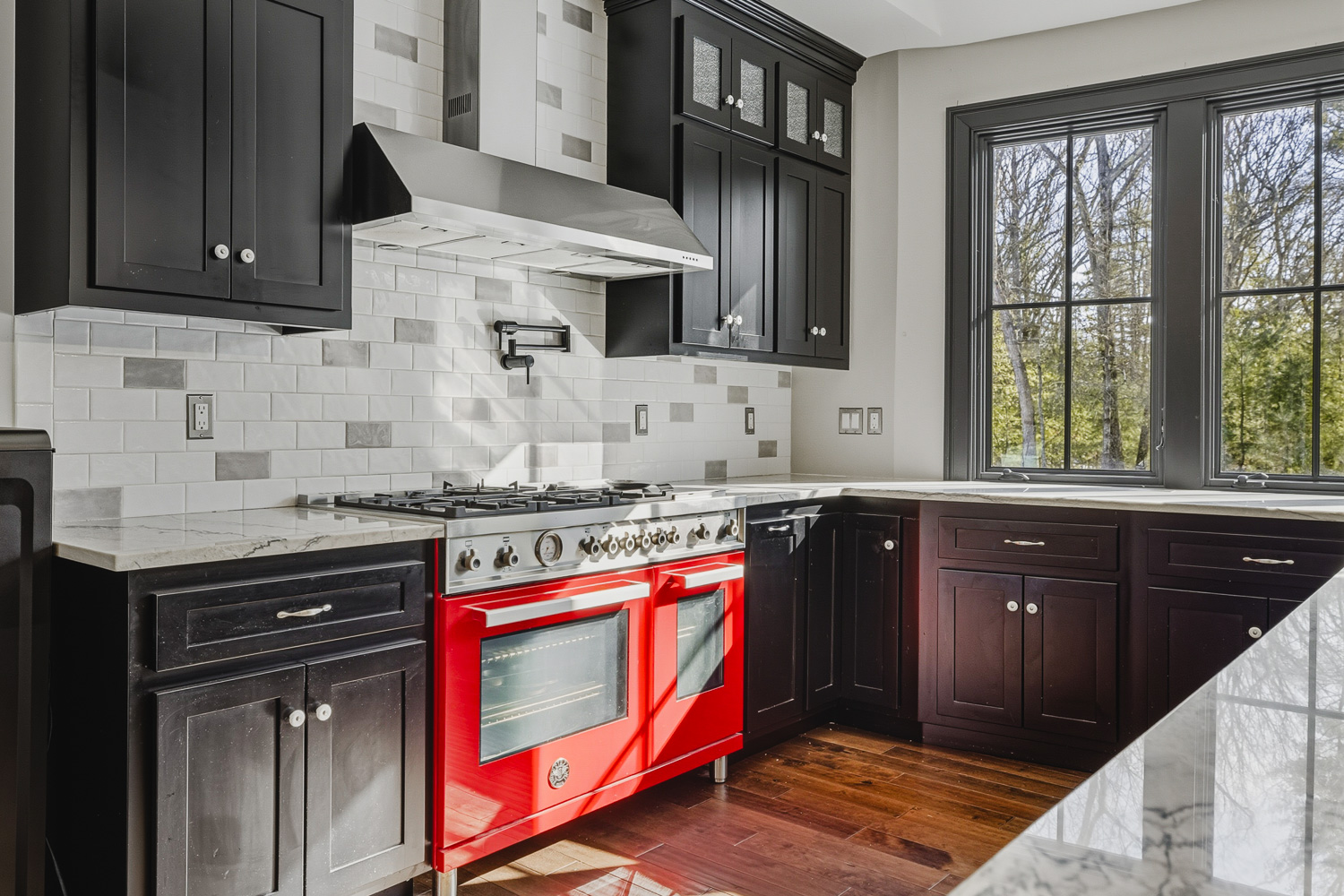 Modern kitchen with dark cabinets, large island, and hardwood floors in Plainville MA home.