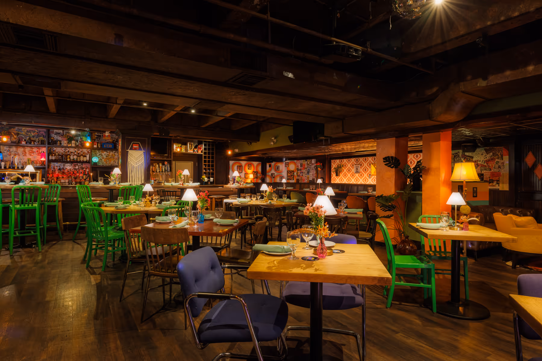 Wide interior view of Back Bay Social The Retro Room in Boston MA showing colorful dining chairs and warm ambient lighting