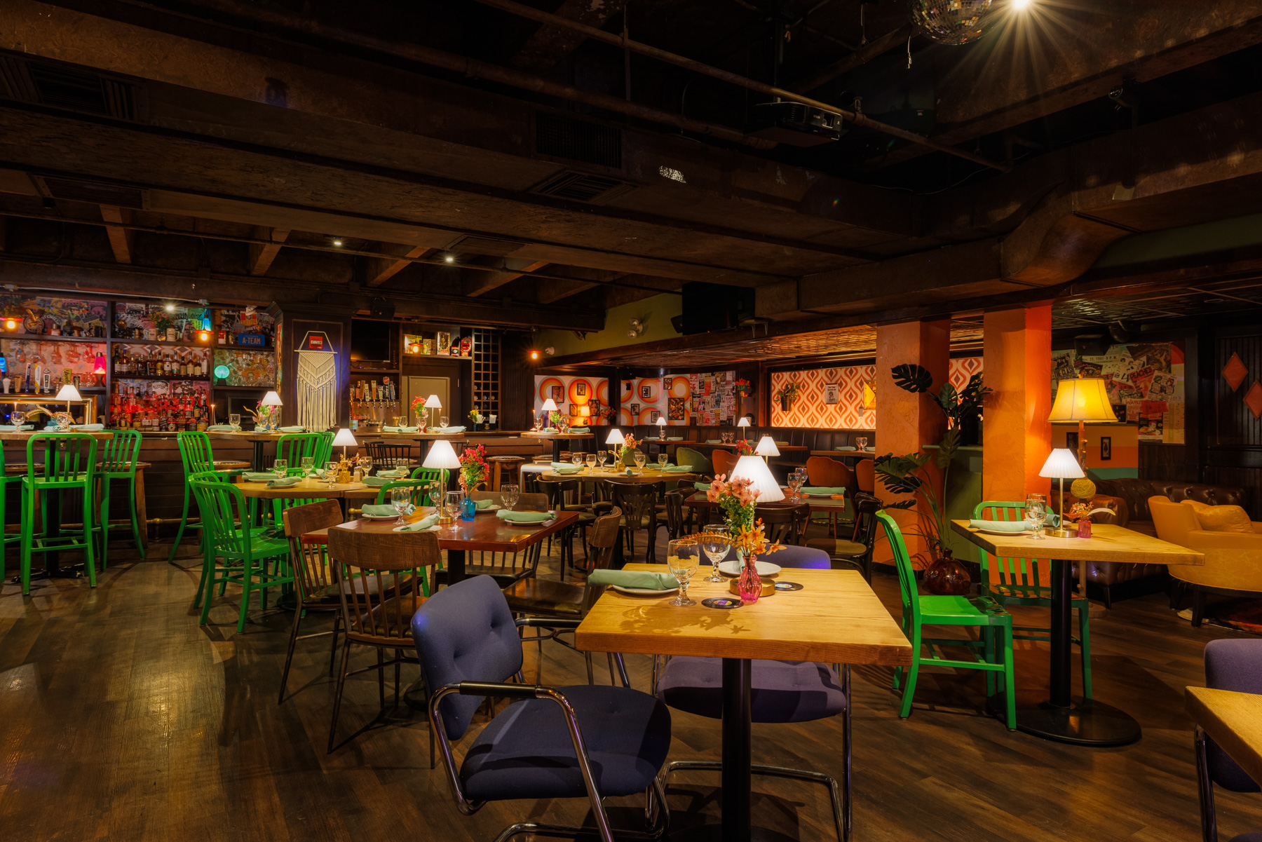 Wide interior view of Back Bay Social The Retro Room in Boston MA showing colorful dining chairs and warm ambient lighting