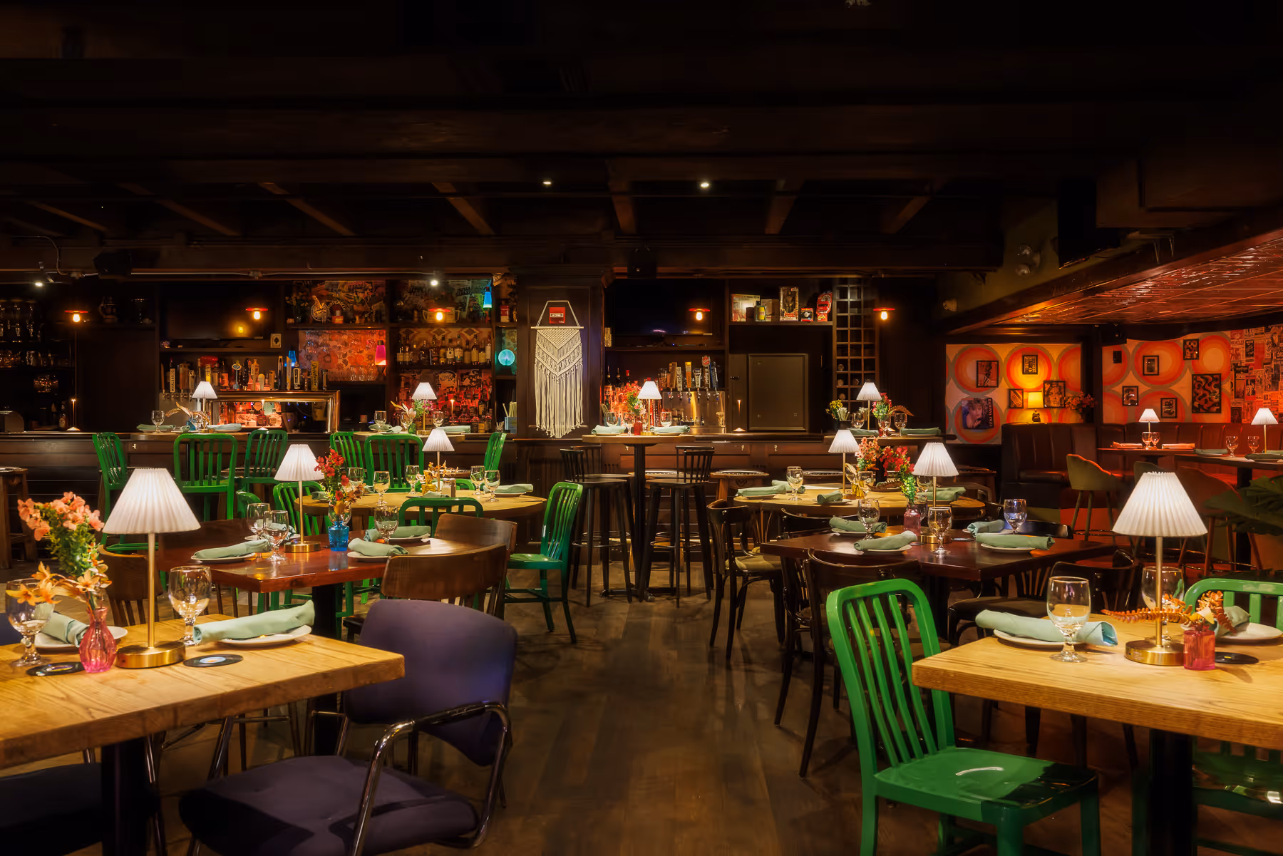 Dining room layout at Back Bay Social Boston featuring green chairs, wood tables, and layered ceiling details