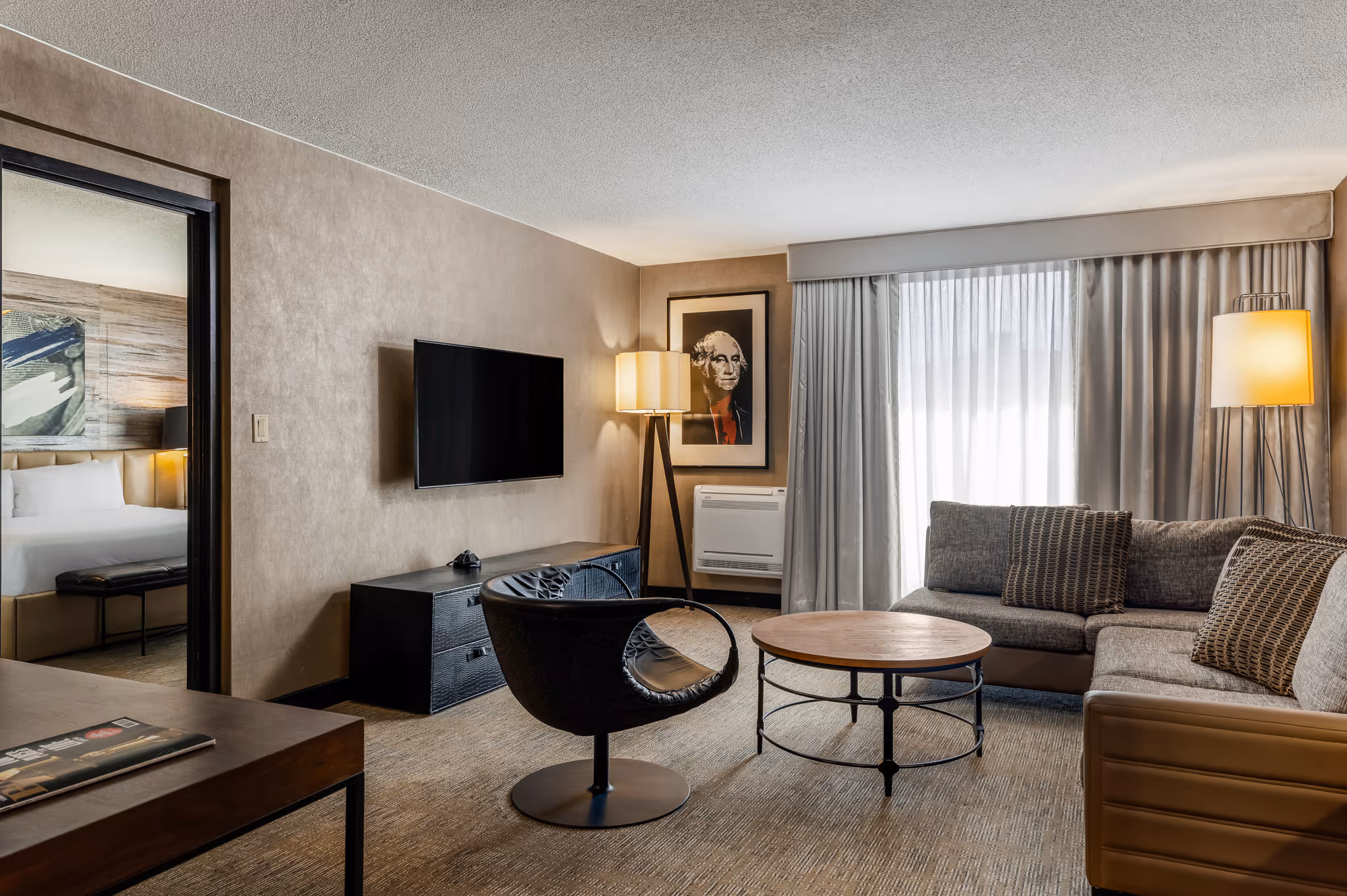Hotel suite living area with seating and TV in Boston hotel