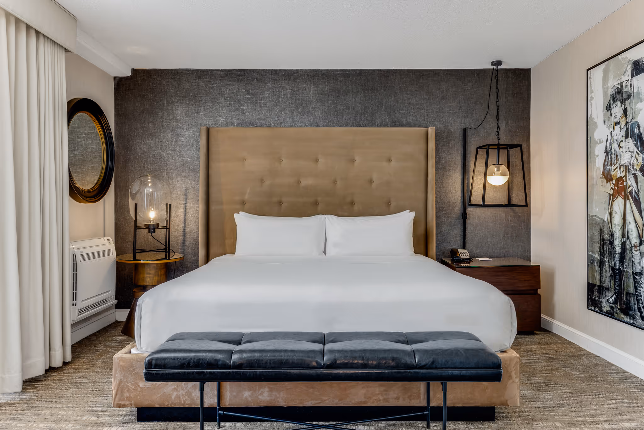 	King bedroom with upholstered headboard and accent wall at Revere Hotel Boston