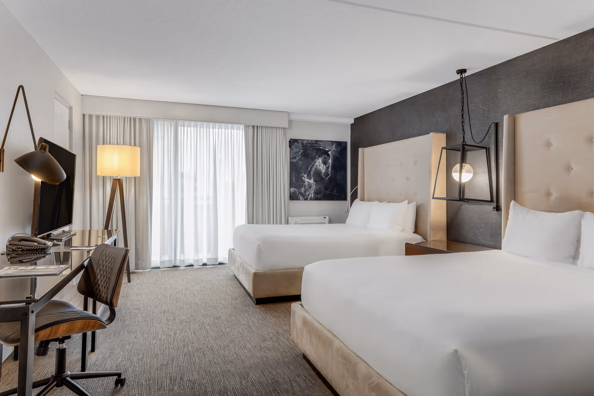 Bright hotel room with bed, desk, and seating area in Boston