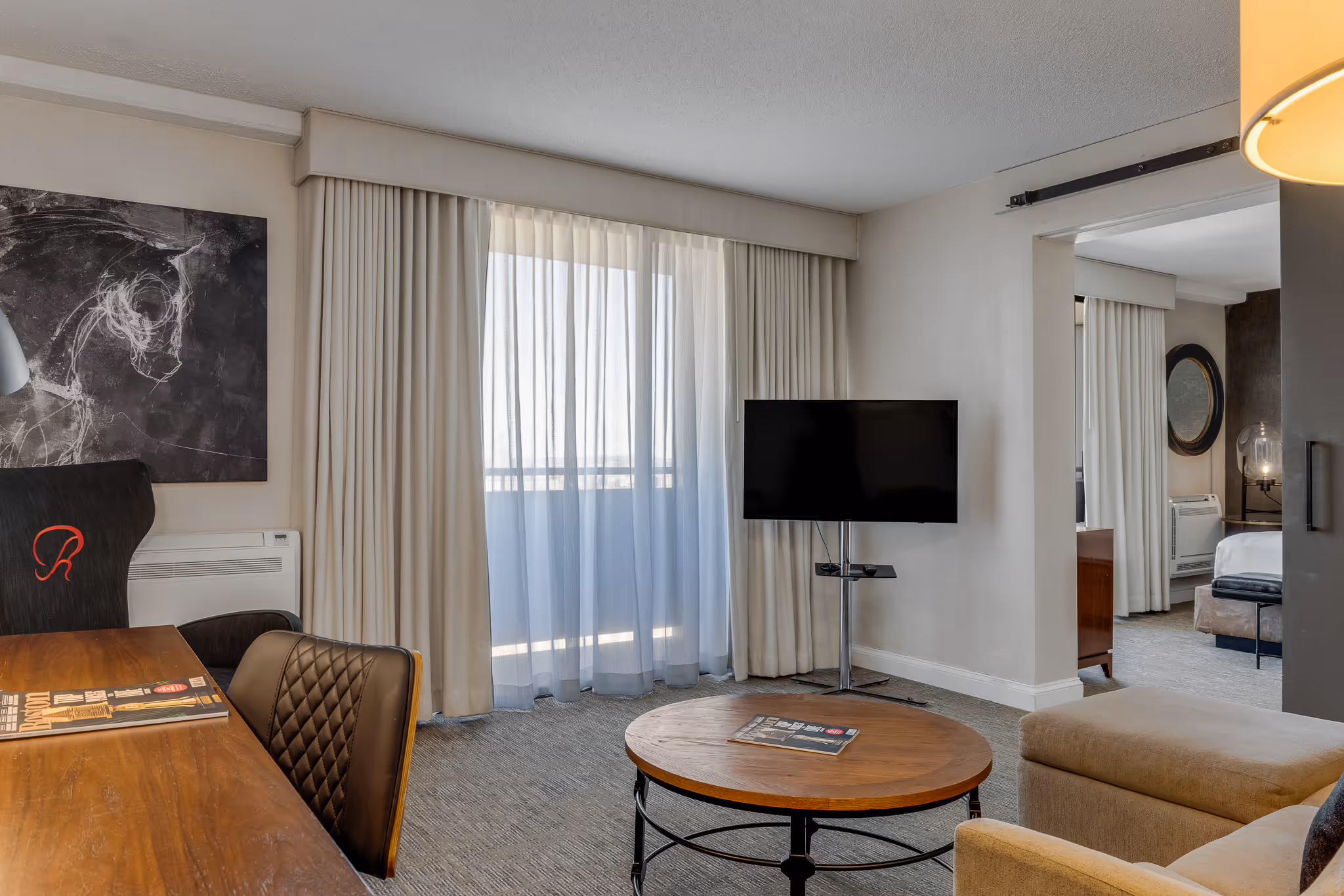 Hotel room with seating area and TV in Boston guest room