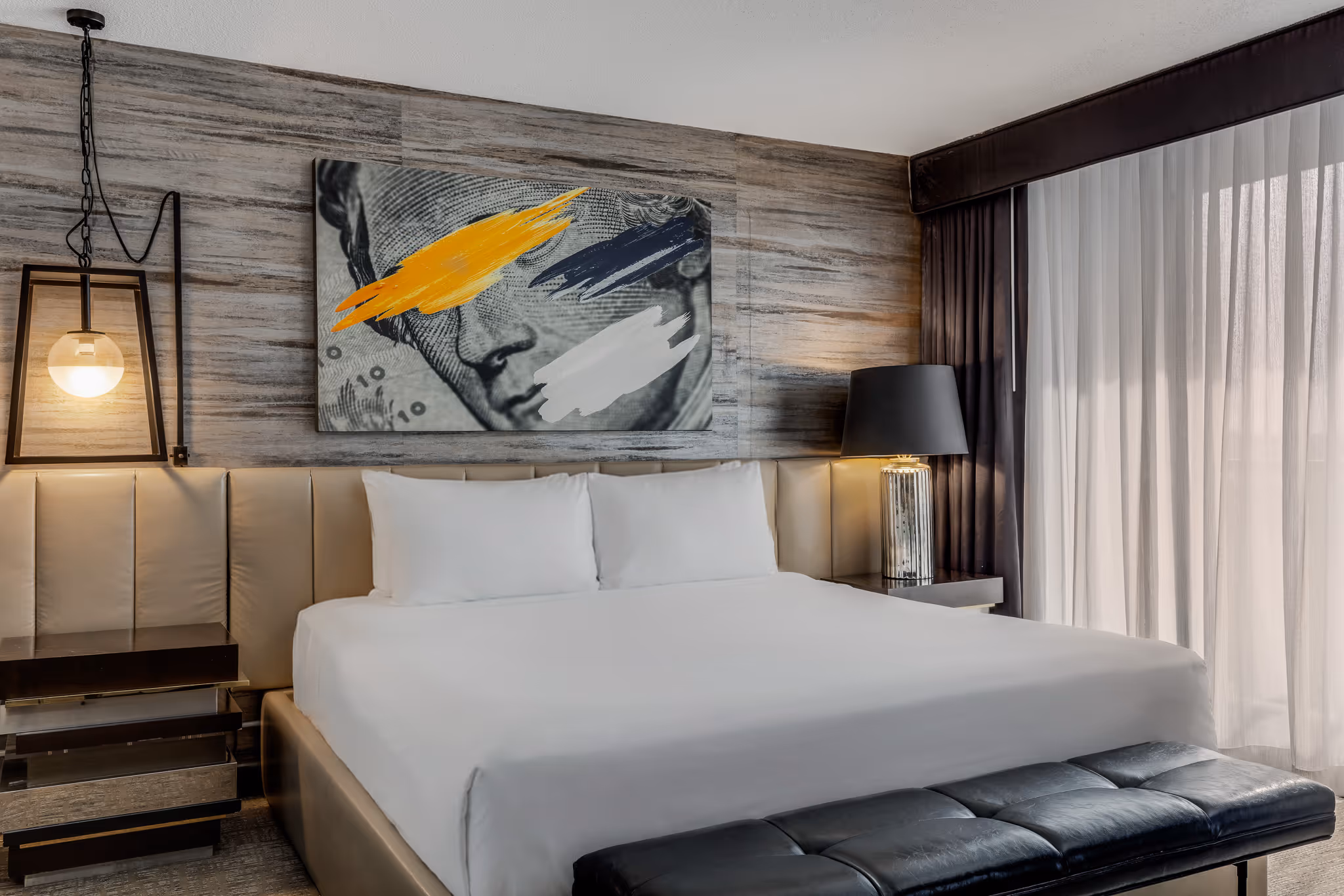 Hotel bedroom with modern wall art and upholstered headboard