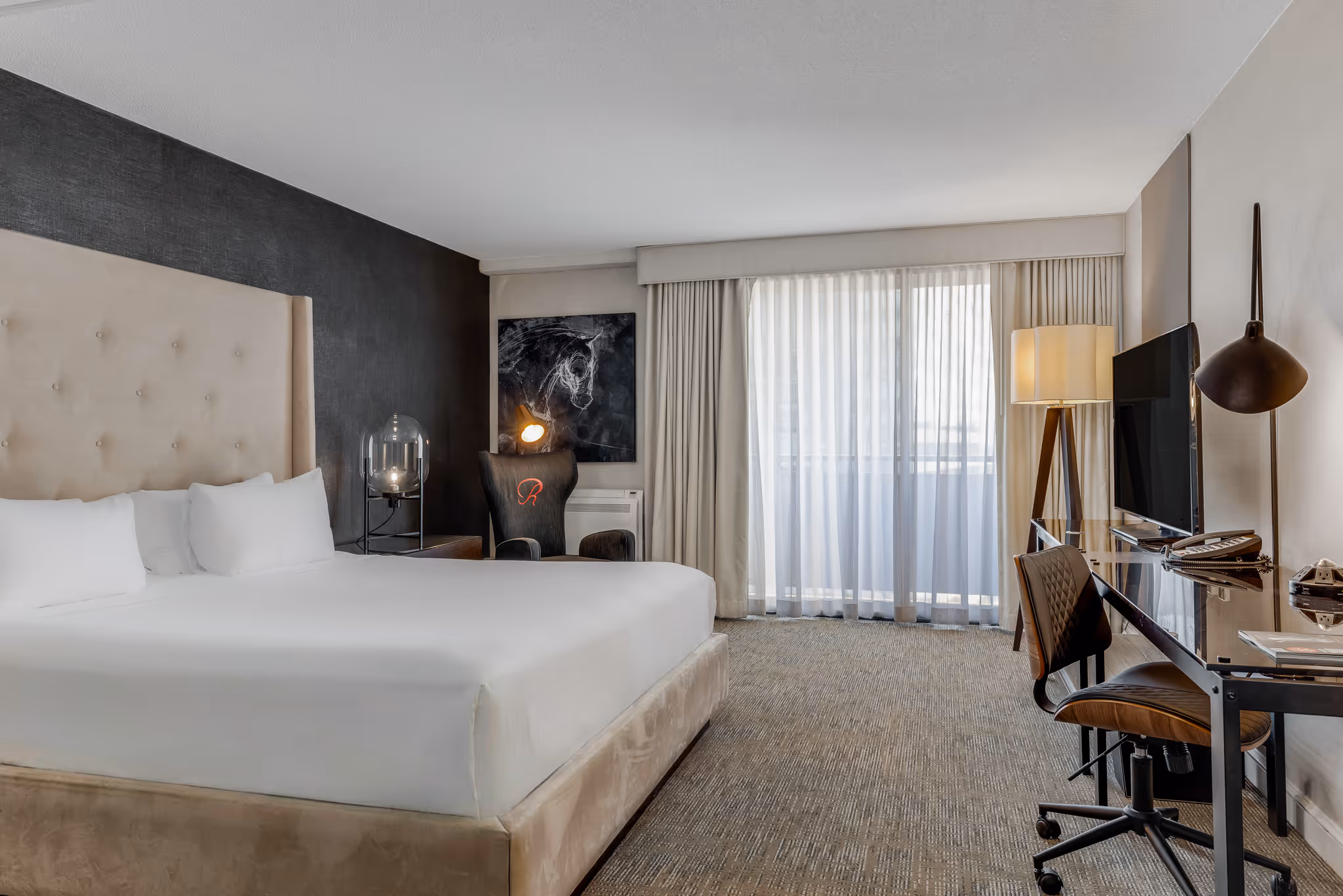 King bedroom with accent wall and soft natural light in hotel