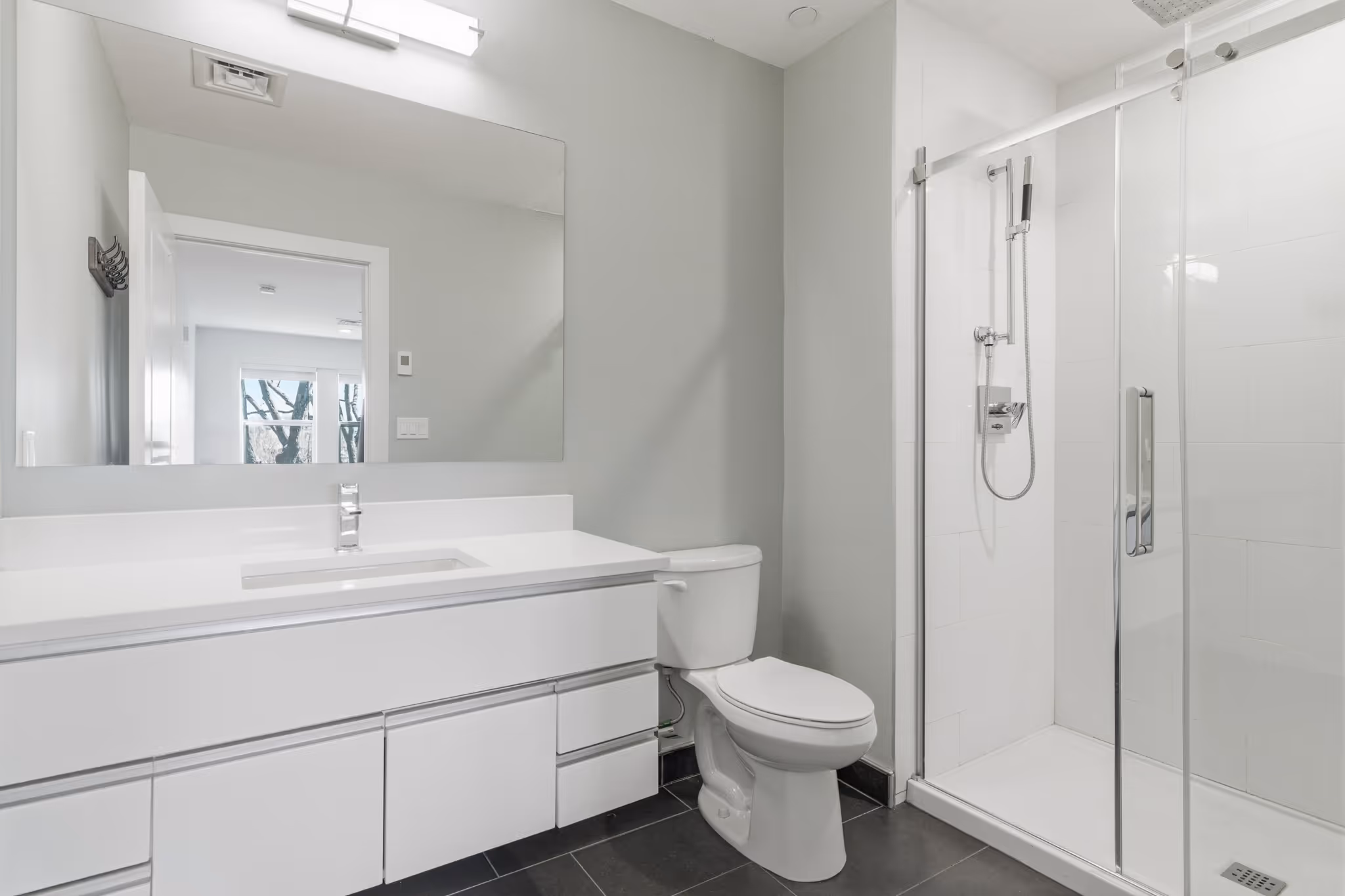 Modern bathroom with white floating vanity and glass-enclosed shower – Orient Heights condo, East Boston