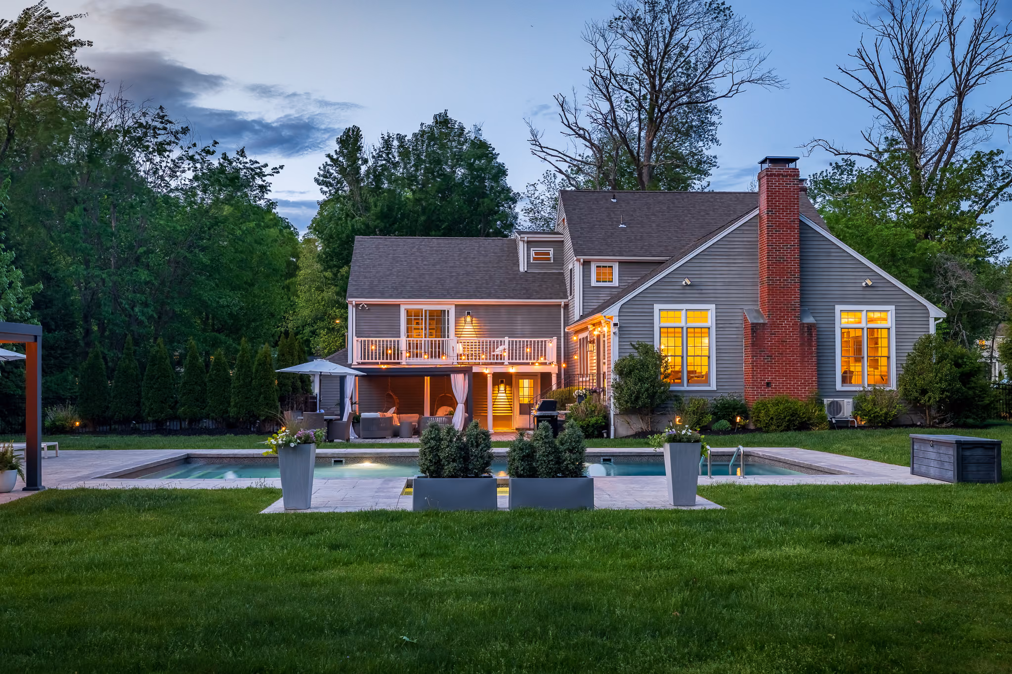 Real twilight photography in Boston. 3-5 dusk photos of the property with exterior lights on, showcasing curb appeal and outdoor spaces.