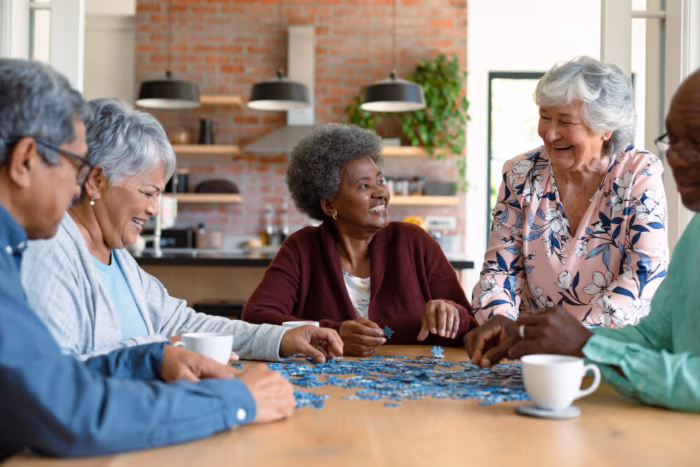 Senior adults engaged in a jigsaw puzzle together at home, enjoying a leisurely and social activity.