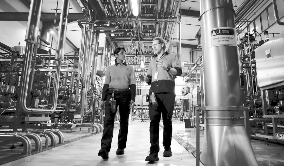 Lion Co. employees inside a bottling factory discussing security.