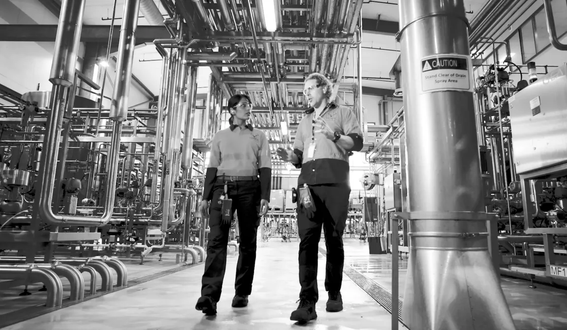Lion Co. employees inside a bottling factory discussing security.