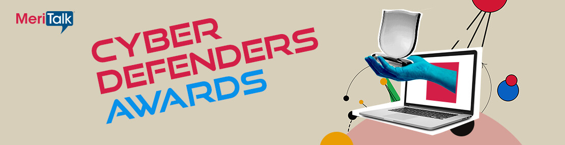 A hand coming out of a laptop screen holding a MeriTalk's Cyber Defenders award