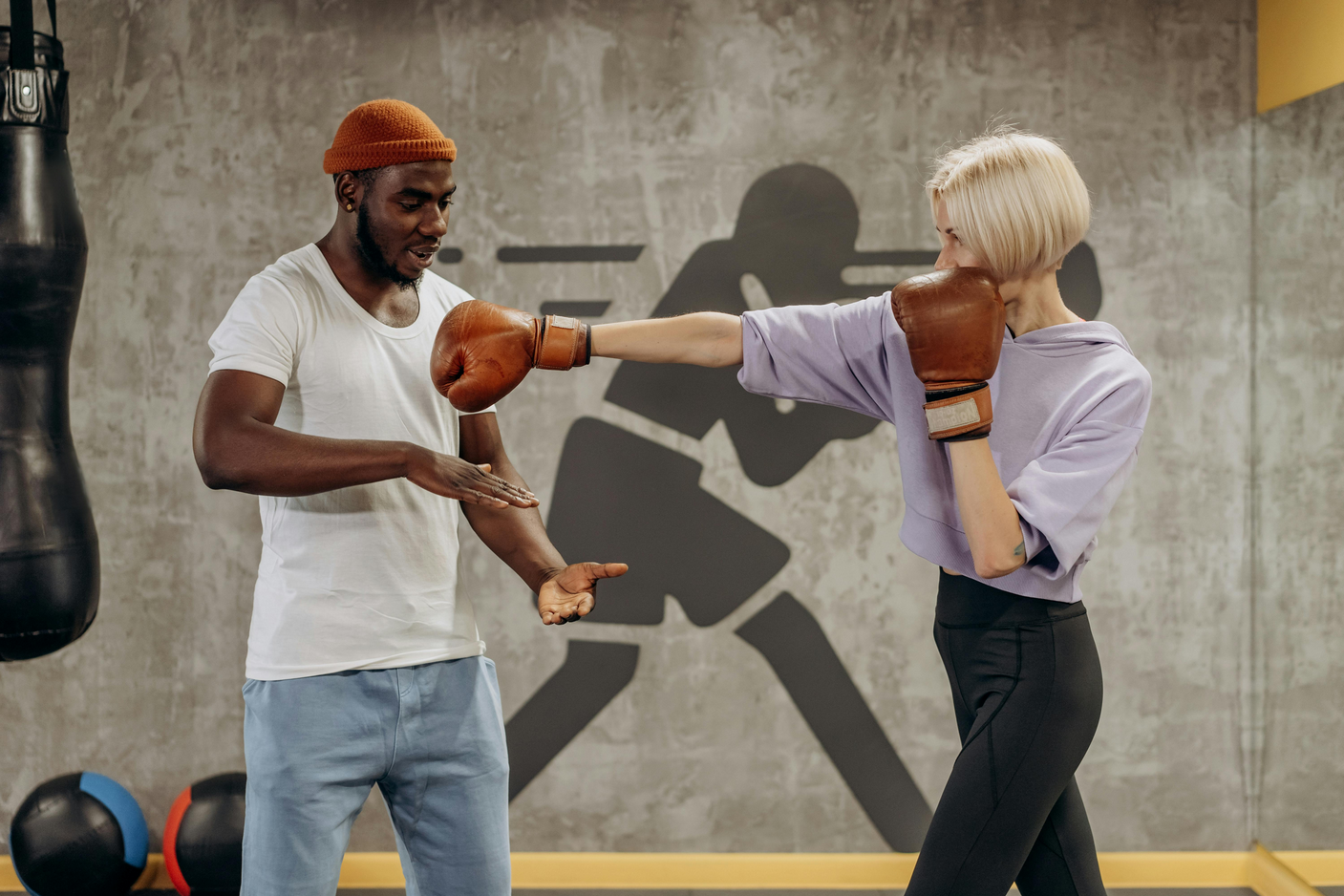 A trainer teaching a student how to perform a jab.