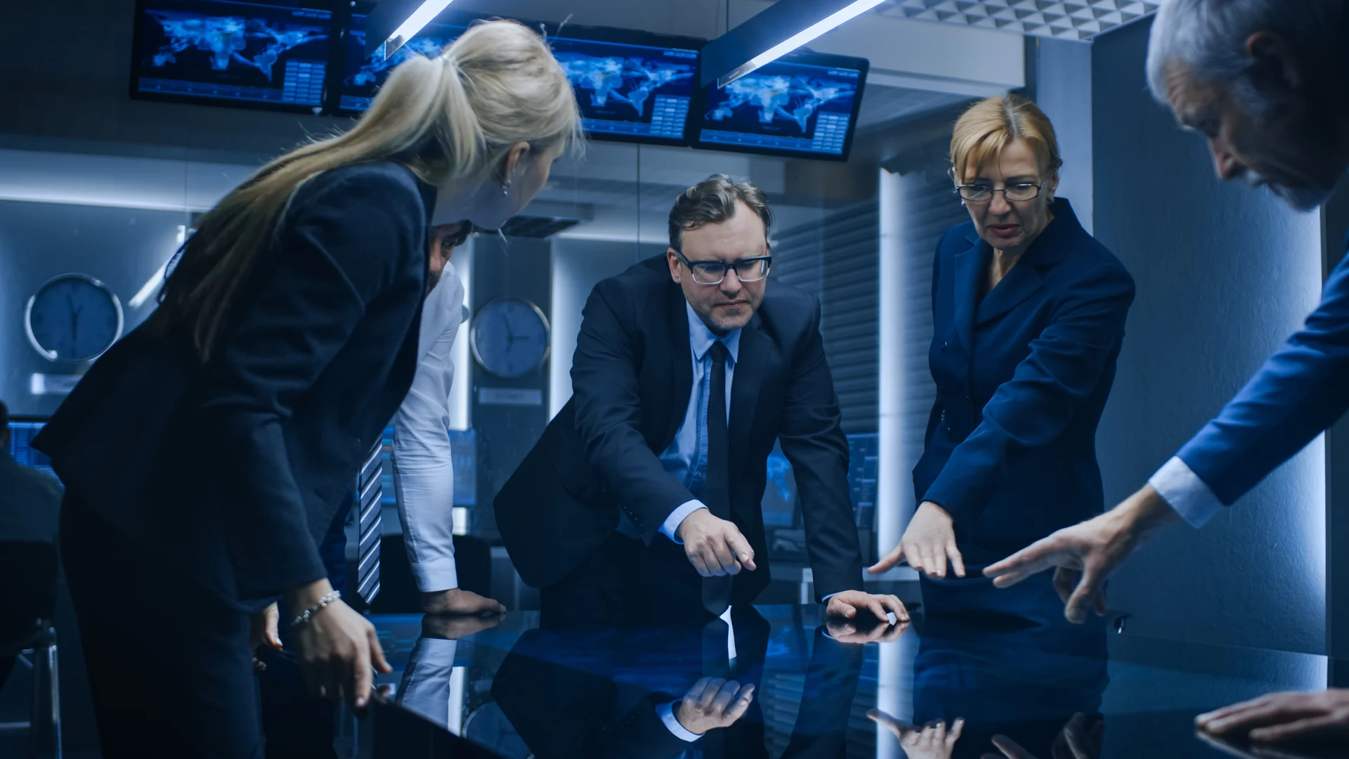 a group of people in suits looking at a table