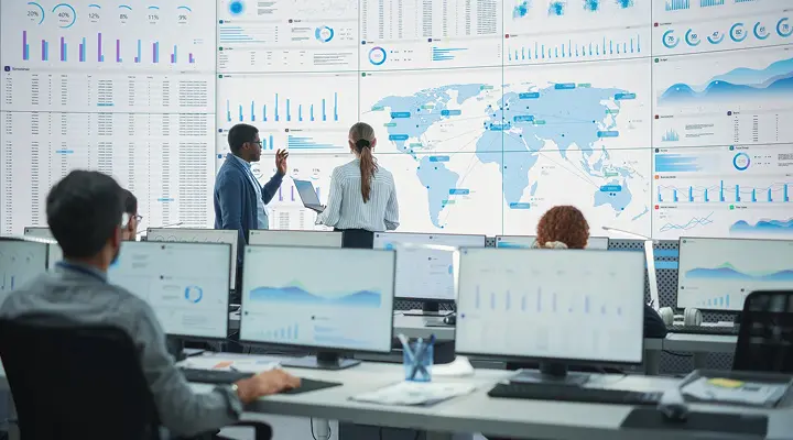 a group of people looking at a large screen