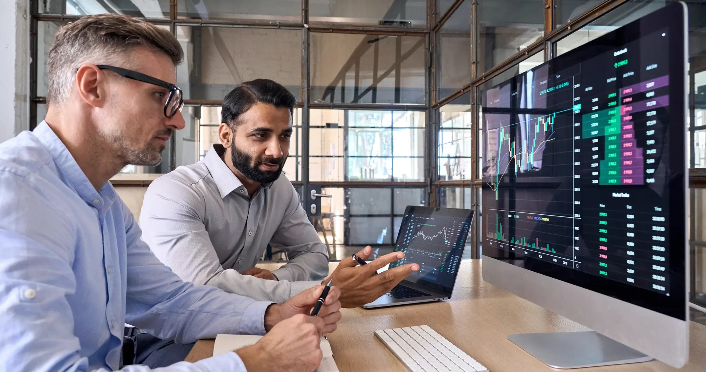 a group of men looking at a computer screen