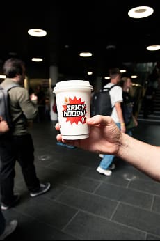 Photo of someone holding a Spicy Noods branded cup of instant noodles
