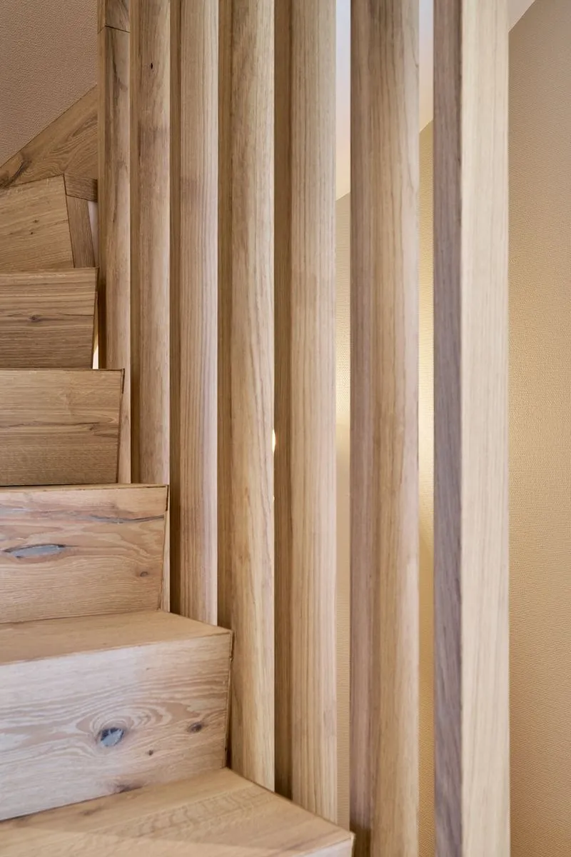 Holztreppe mit vertikalen Lamellen und warmen, natürlichen Holztönen