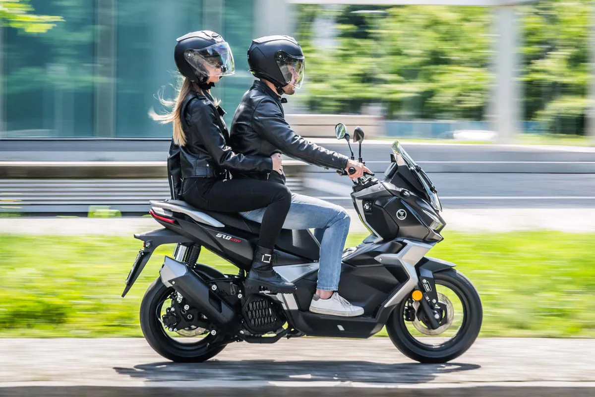 Rider cruising on the VOGE SR180 ADV scooter on a sunny day.