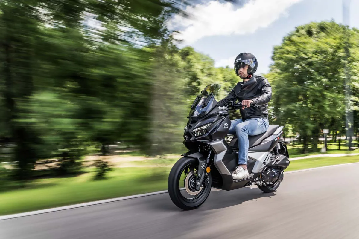 Rider on the VOGE SR180 ADV scooter driving on a clean city road.