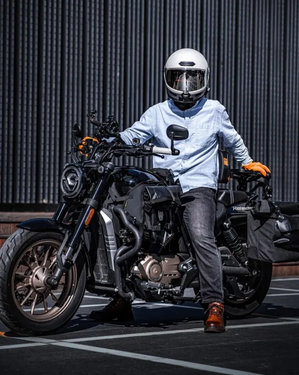 Rider posing with the Voge CU250 motorcycle in a modern urban setting.